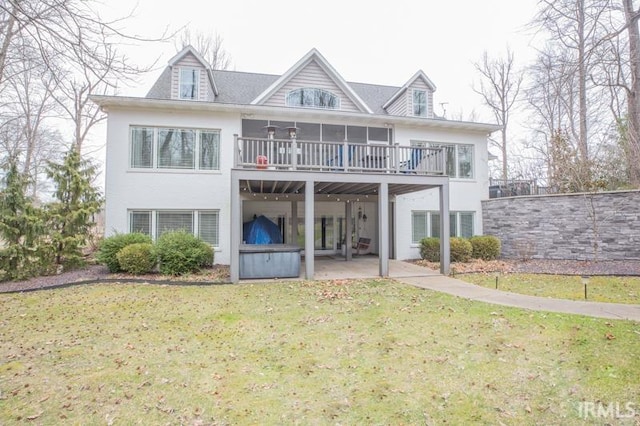 back of house with a yard, a patio area, and a hot tub