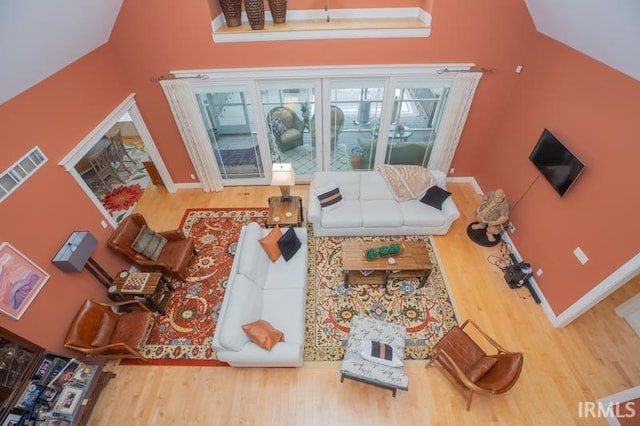 living area featuring visible vents, baseboards, and wood finished floors