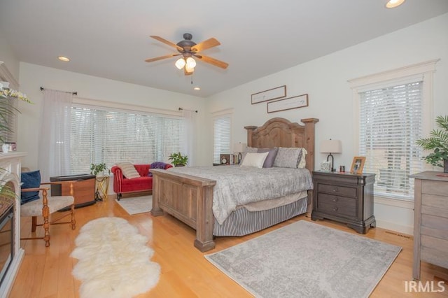 bedroom featuring recessed lighting, light wood-type flooring, and multiple windows