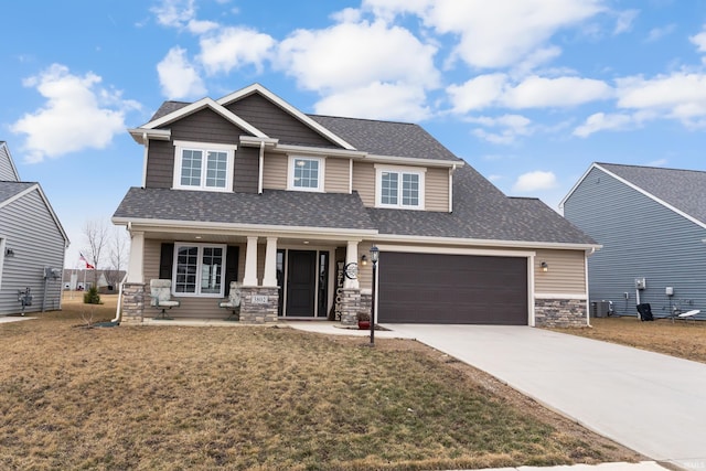 craftsman inspired home featuring central AC unit, driveway, roof with shingles, a porch, and stone siding