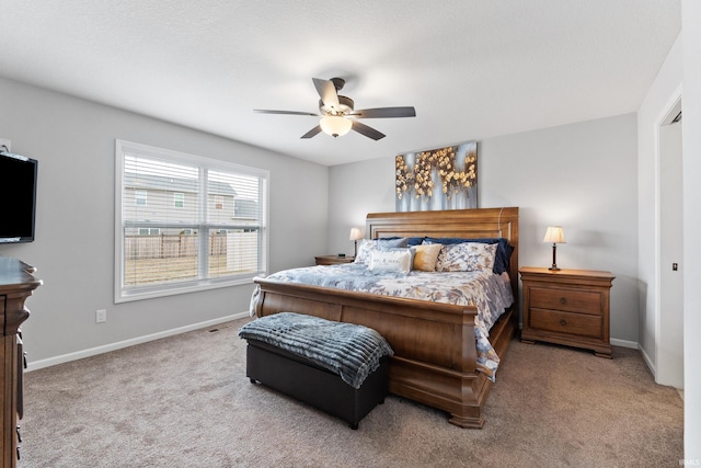 carpeted bedroom with baseboards and a ceiling fan