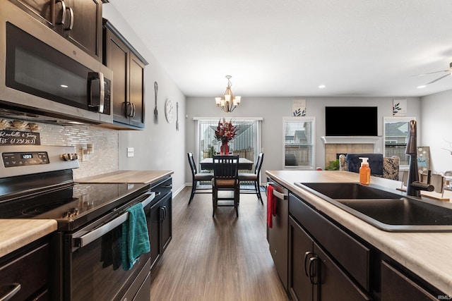 kitchen with a wealth of natural light, decorative backsplash, appliances with stainless steel finishes, a fireplace, and a sink