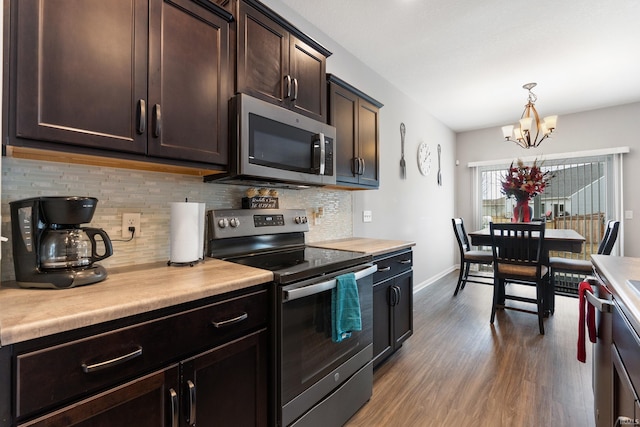 kitchen featuring dark brown cabinetry, light countertops, decorative backsplash, wood finished floors, and stainless steel appliances