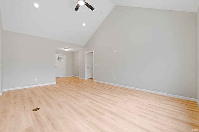 spare room featuring baseboards, high vaulted ceiling, ceiling fan, and light wood finished floors