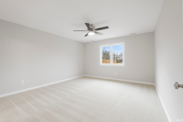 spare room featuring a ceiling fan, visible vents, light colored carpet, and baseboards