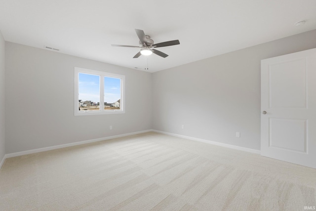 unfurnished room with a ceiling fan, baseboards, visible vents, and light carpet