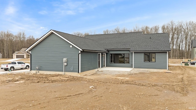 back of house with a shingled roof