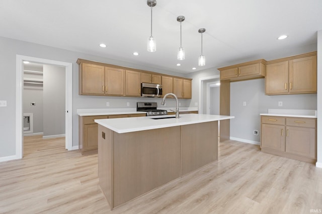 kitchen with a sink, recessed lighting, light wood-style floors, appliances with stainless steel finishes, and light countertops