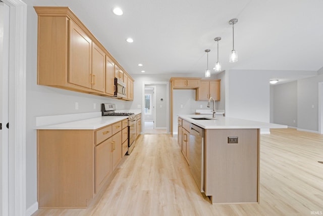 kitchen featuring a sink, light countertops, light wood-style flooring, and stainless steel appliances