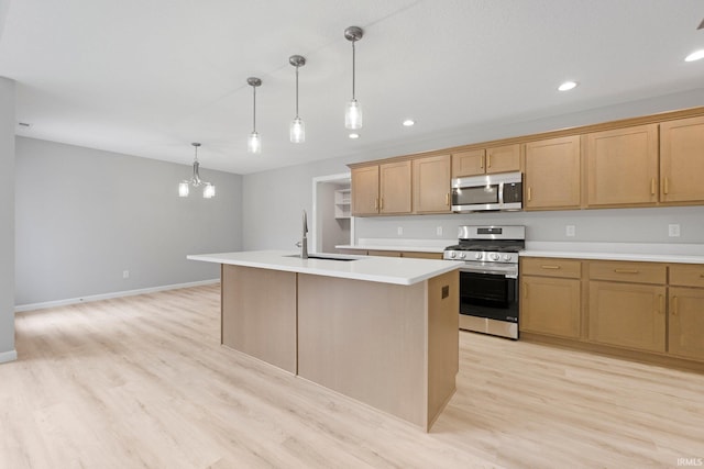 kitchen featuring light wood finished floors, an island with sink, light countertops, appliances with stainless steel finishes, and a sink