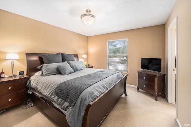 bedroom featuring baseboards, light carpet, and a textured ceiling