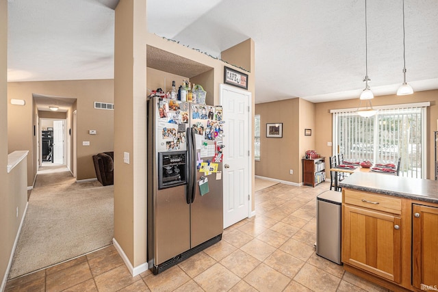 kitchen with visible vents, stainless steel fridge, light colored carpet, vaulted ceiling, and hanging light fixtures