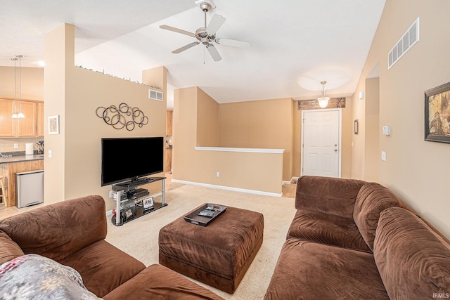 living area featuring visible vents, light colored carpet, high vaulted ceiling, and baseboards