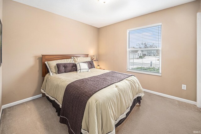 carpeted bedroom featuring baseboards