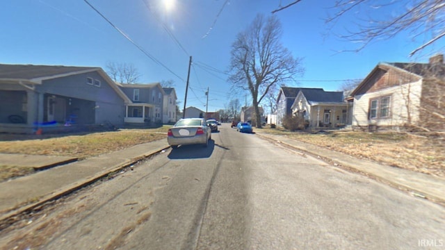 view of street with a residential view, curbs, and sidewalks