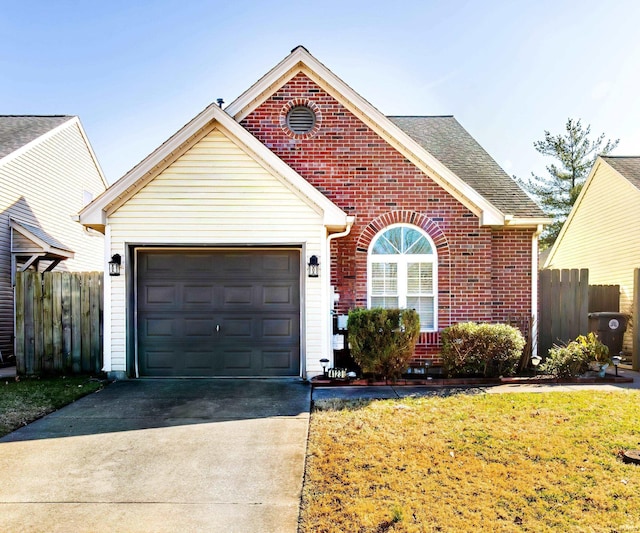 view of front of house with brick siding, driveway, an attached garage, and fence