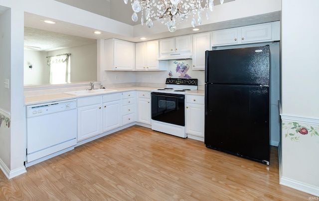 kitchen with under cabinet range hood, dishwasher, freestanding refrigerator, electric range, and a sink