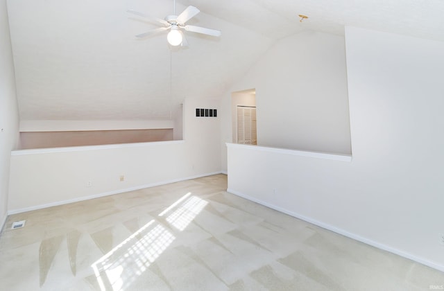 carpeted empty room with visible vents, a ceiling fan, lofted ceiling, and baseboards