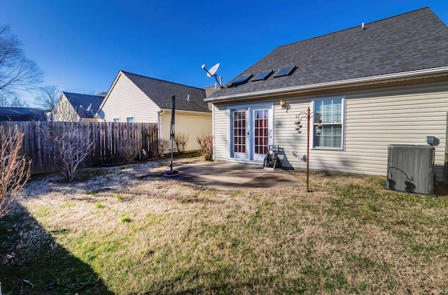 rear view of house with a patio, cooling unit, fence, french doors, and a lawn