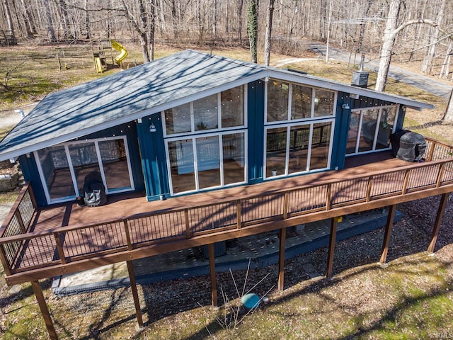 back of house featuring a sunroom and a wooden deck