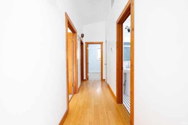 hall featuring baseboards and light wood-style flooring