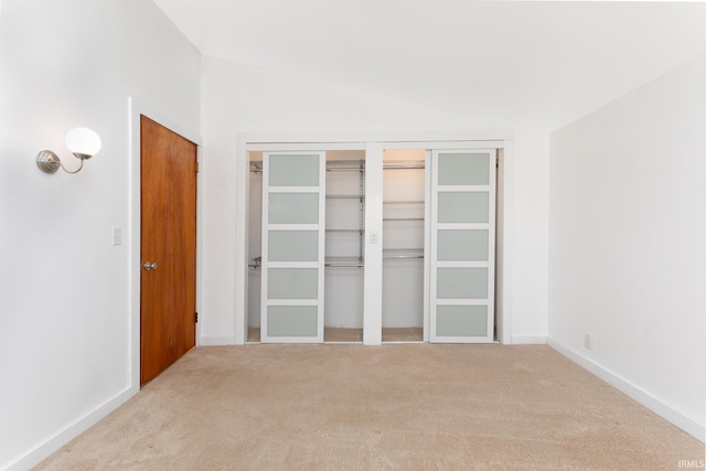 unfurnished bedroom with baseboards, carpet floors, and vaulted ceiling