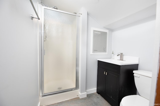 bathroom with a shower stall, toilet, vanity, and baseboards