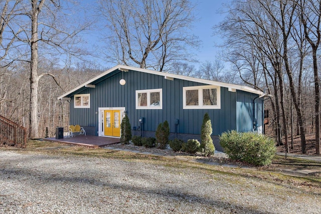 view of front of property with brick siding, french doors, board and batten siding, and a patio