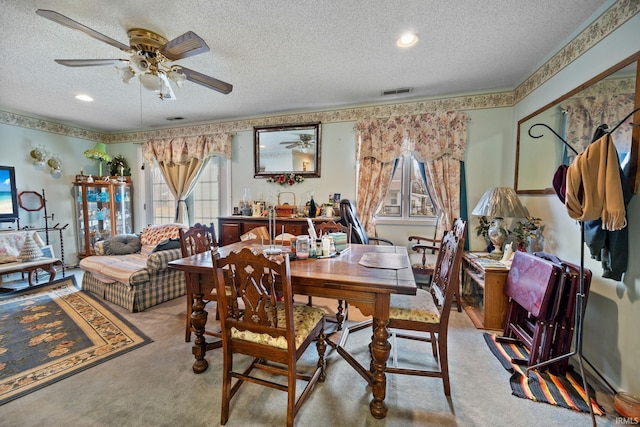 dining space featuring carpet flooring, ceiling fan, a textured ceiling, and visible vents