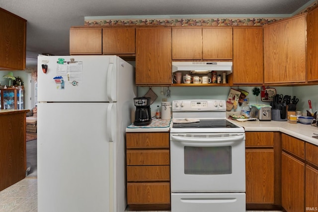 kitchen featuring under cabinet range hood, brown cabinetry, white appliances, and light countertops