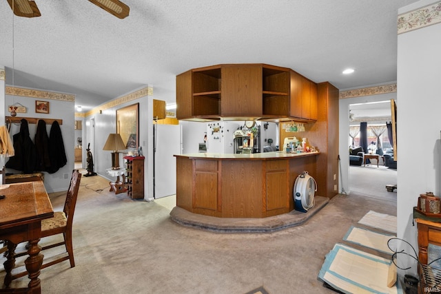 kitchen featuring open shelves, freestanding refrigerator, brown cabinetry, light colored carpet, and ceiling fan