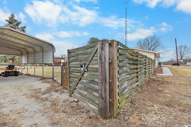 view of outdoor structure with a detached carport and driveway