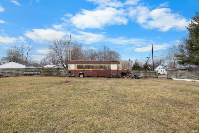 view of yard featuring an outdoor structure and fence