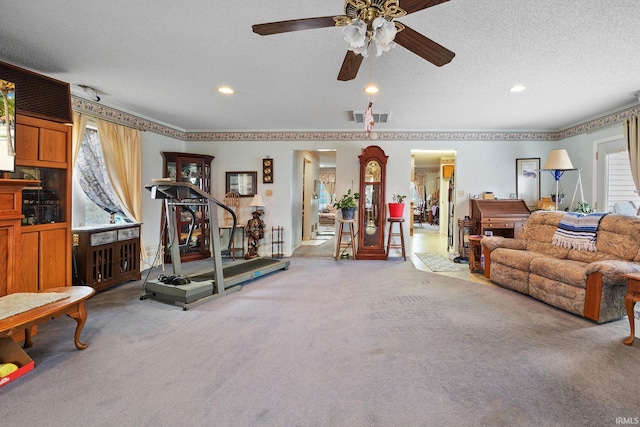 exercise room featuring visible vents, a textured ceiling, and carpet flooring