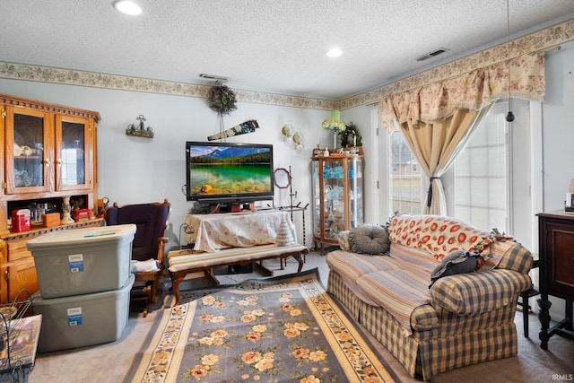 carpeted living room featuring visible vents and a textured ceiling