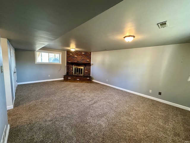 unfurnished living room featuring a brick fireplace, visible vents, dark colored carpet, and baseboards