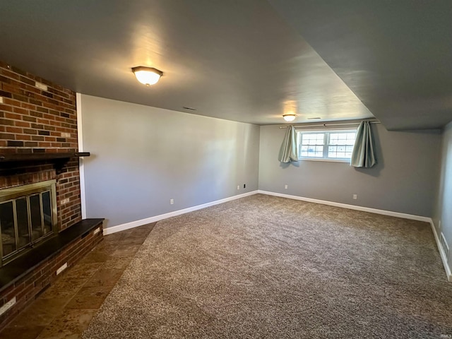 interior space with dark carpet, baseboards, and a fireplace
