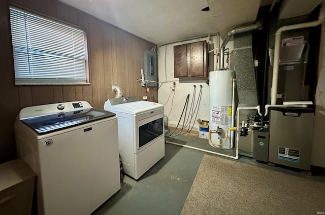 laundry room featuring water heater, wood walls, laundry area, and washing machine and clothes dryer