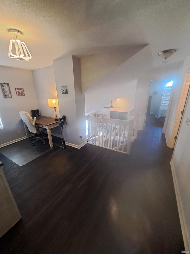 dining area featuring plenty of natural light, a textured ceiling, baseboards, and wood finished floors