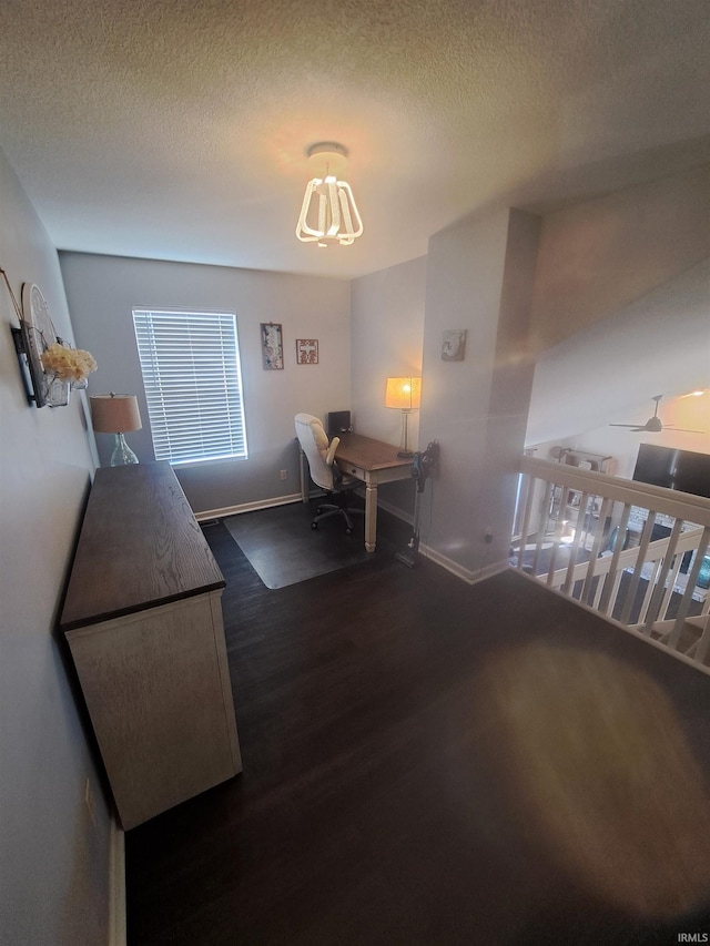 dining room with a textured ceiling, baseboards, and wood finished floors