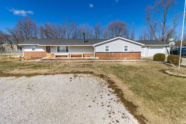 single story home with a front lawn, a garage, and brick siding