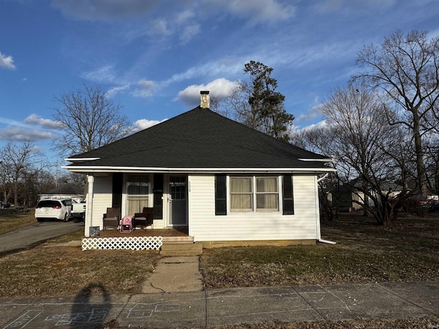 bungalow-style home with covered porch and roof with shingles