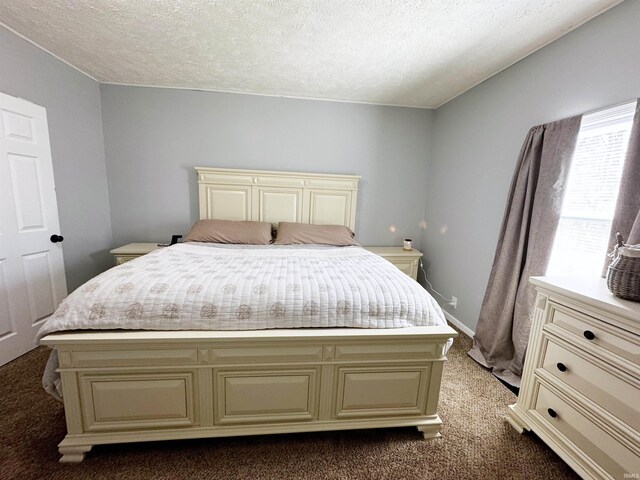 bedroom with carpet flooring, baseboards, and a textured ceiling