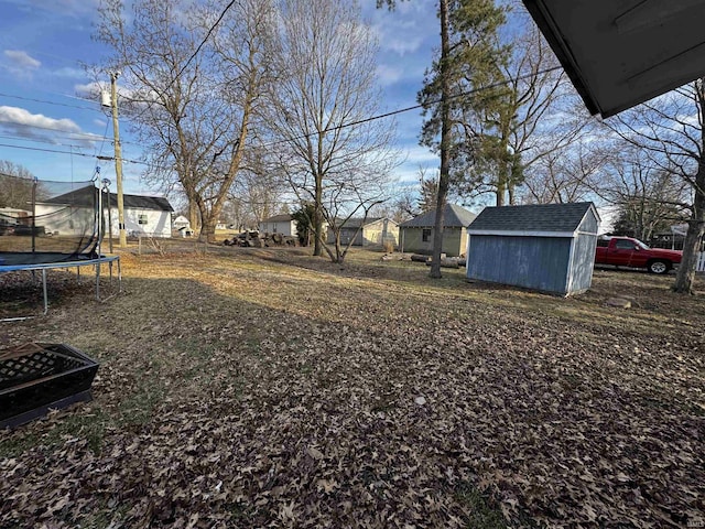 view of yard with a storage unit, a trampoline, and an outdoor structure