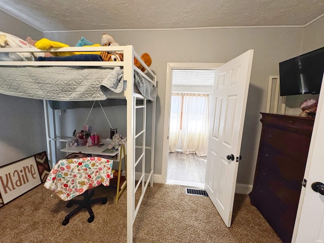 bedroom featuring visible vents, a textured ceiling, and carpet