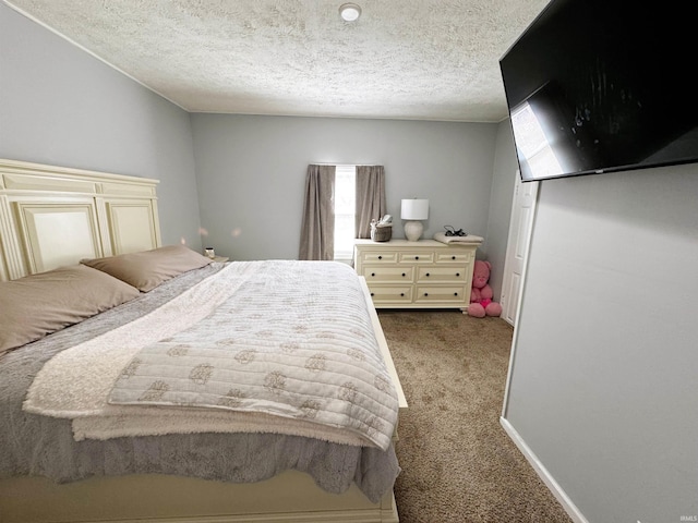 bedroom with baseboards, carpet, and a textured ceiling