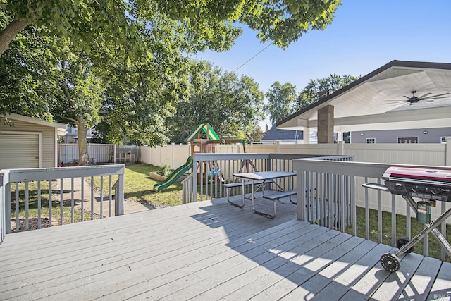 wooden terrace featuring a lawn, a fenced backyard, and a playground