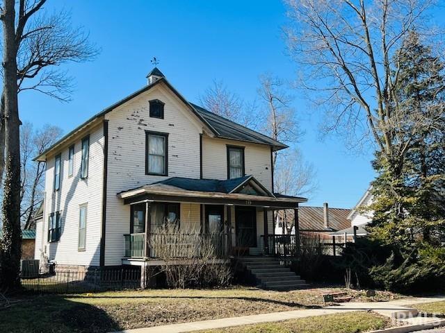 view of front of house featuring central air condition unit, covered porch, and fence