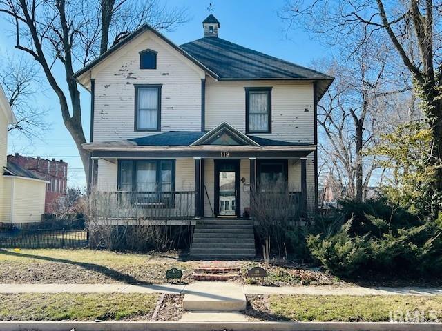 view of front of home featuring a porch and fence