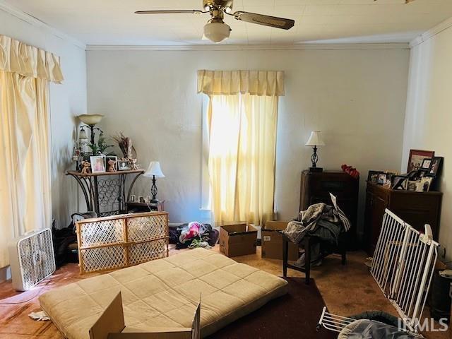 bedroom with ceiling fan and crown molding